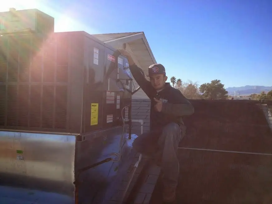 HVAC technician performing AC Tune-Up on a rooftop unit in James Island
